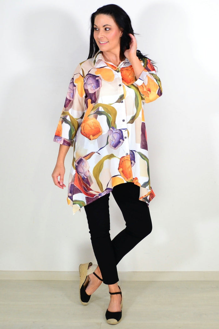 Orange artwork swirls tunic shirt by Wishstone, featuring vibrant abstract patterns and flowing fabric, displayed flat.
