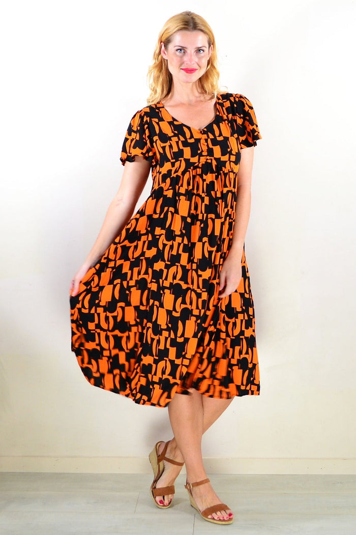 Orange and black print tunic dress by Hourglass, featuring a stylish design and comfortable fit, shown in the product image.