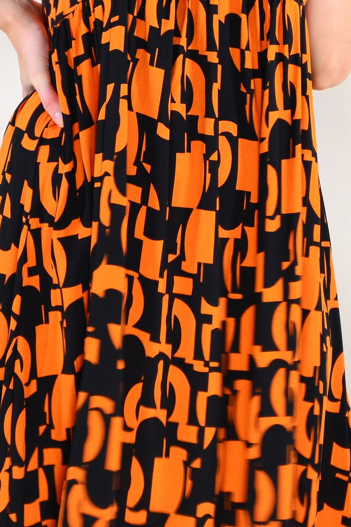 Hourglass orange and black print tunic dress with long sleeves and a relaxed fit, displayed on a hanger.