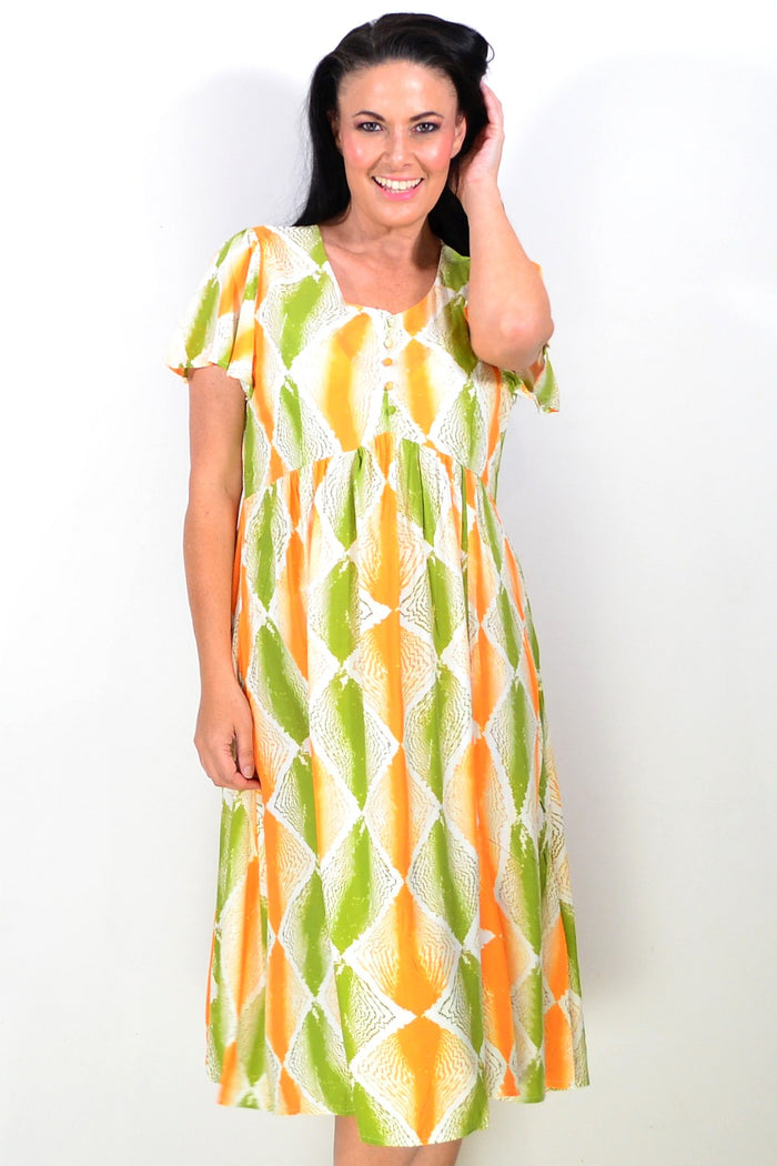 Bright orange and green patterned tunic dress by Hourglass with a relaxed fit and flowing fabric, displayed on a mannequin.