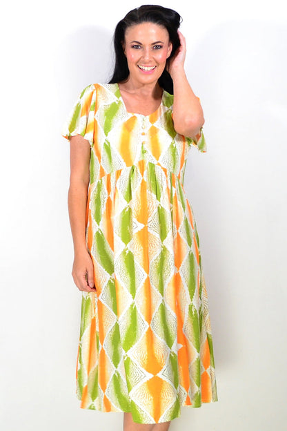 Bright orange and green patterned tunic dress by Hourglass with a relaxed fit and flowing fabric, displayed on a mannequin.