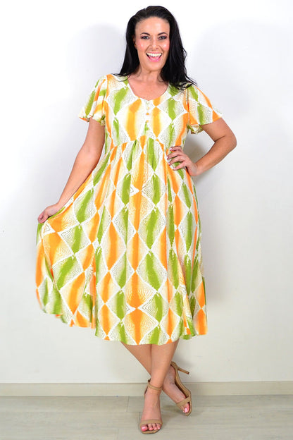 Orange and green patterned Hourglass tunic dress with long sleeves and a relaxed fit, displayed on a hanger.
