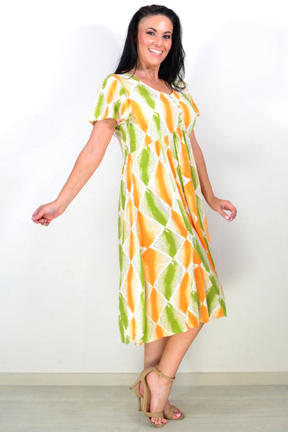 Orange and green patterned Hourglass tunic dress with a relaxed fit, displayed on a hanger against a neutral background.