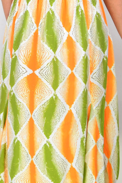Hourglass orange and green patterned tunic dress with long sleeves and relaxed fit, displayed on a hanger.