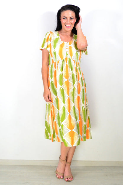 Orange and green patterned Hourglass tunic dress displayed on a hanger with a flowing fabric design.