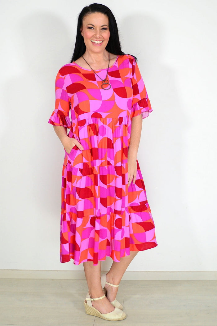 Orange and purple geometric patterned midi dress from New U Collection, stylish tunic with vibrant design and flowing fabric.