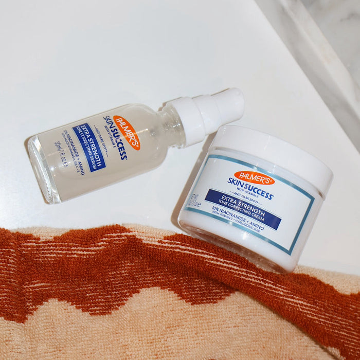 Palmer's Extra Strength range pictured flat lay on a white bathroom counter with a orange towel