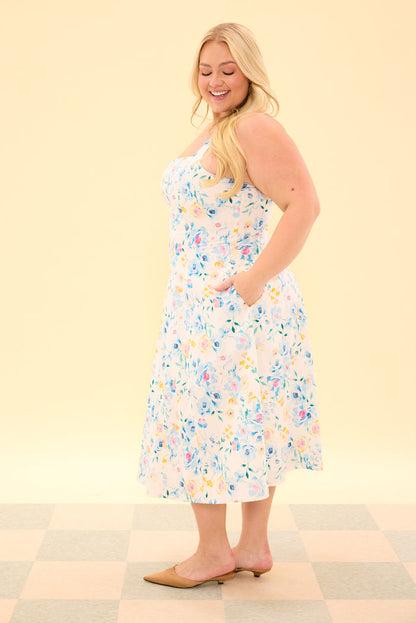 Woman wearing a floral dress on a checkered floor with a light yellow wall background