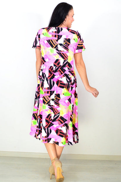 Pink and black abstract tunic dress by Hourglass, featuring a flowy fabric and stylish design, shown on a model.