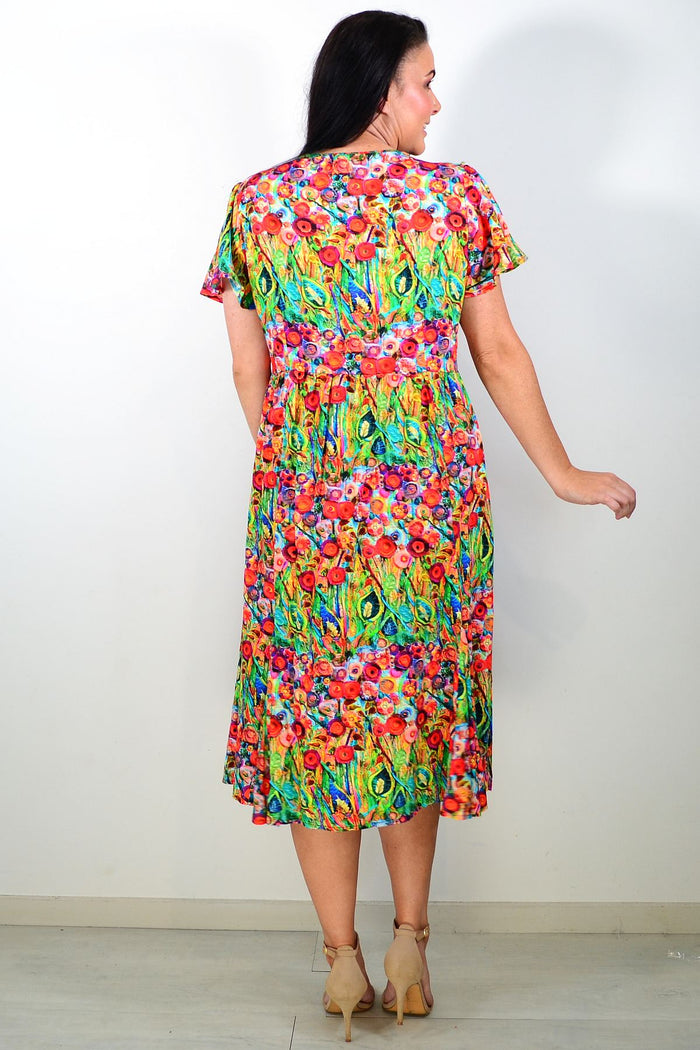 Hourglass Poppy Field Tunic Dress hanging on a hanger with a floral print and flowing fabric, showcasing casual boho style.