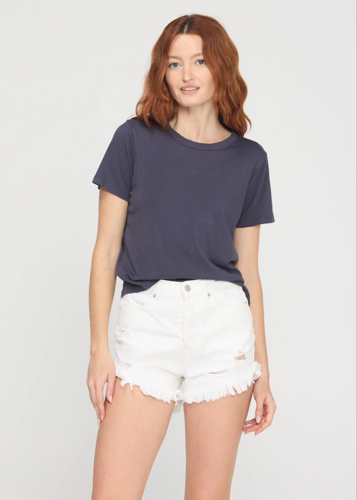 Woman wearing a charcoal grey crewneck t-shirt with white denim shorts