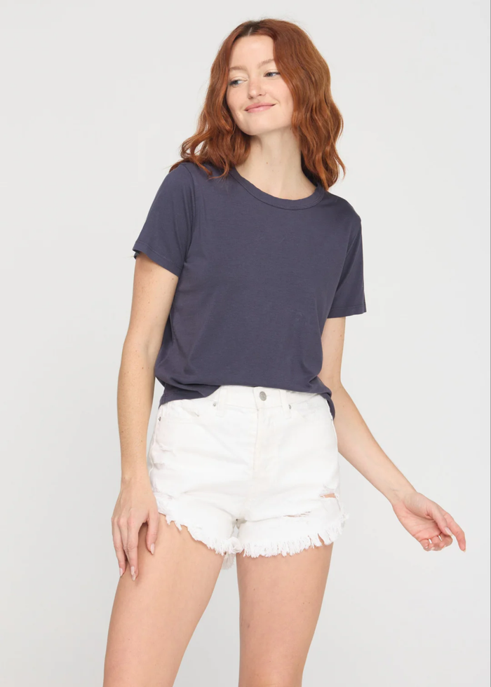 Woman wearing a charcoal grey crewneck t-shirt with white denim shorts