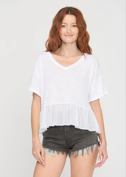 Woman wearing a white v-neck tee with black denim shorts