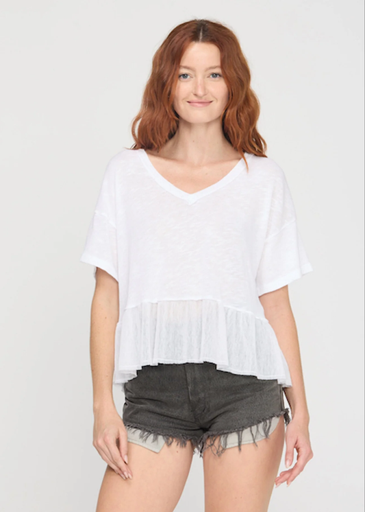 Woman wearing a white v-neck tee with black denim shorts