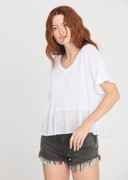 Woman wearing a white v-neck tee with black denim shorts