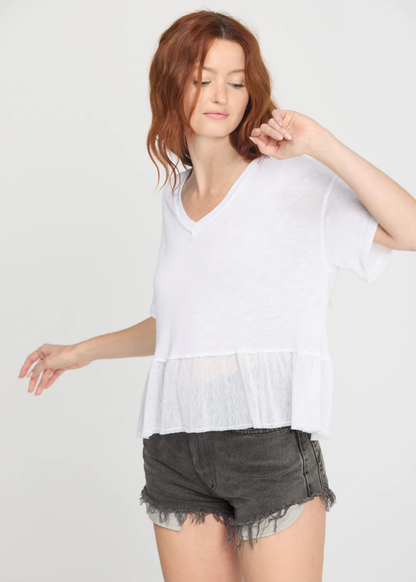 Woman wearing a white v-neck tee with black denim shorts