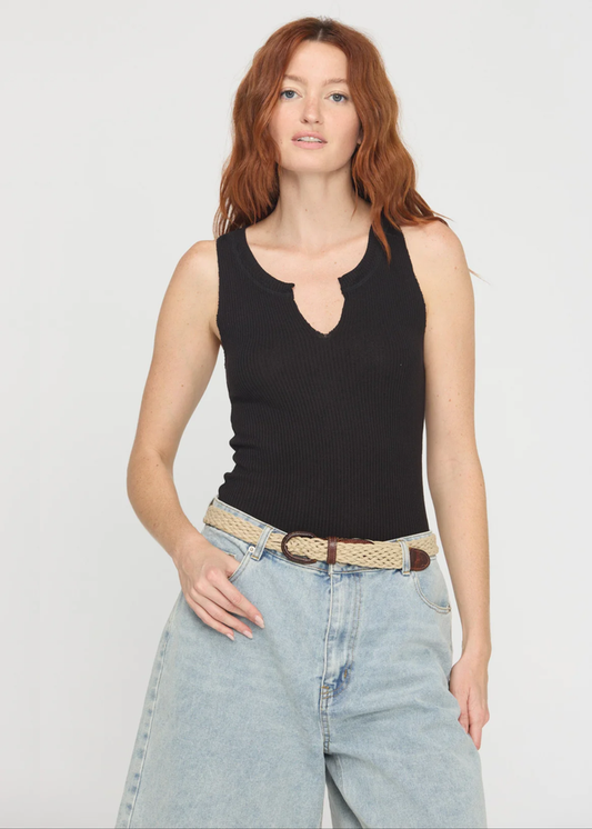 Woman wearing a notch neck black tank top with denim shorts and a belt