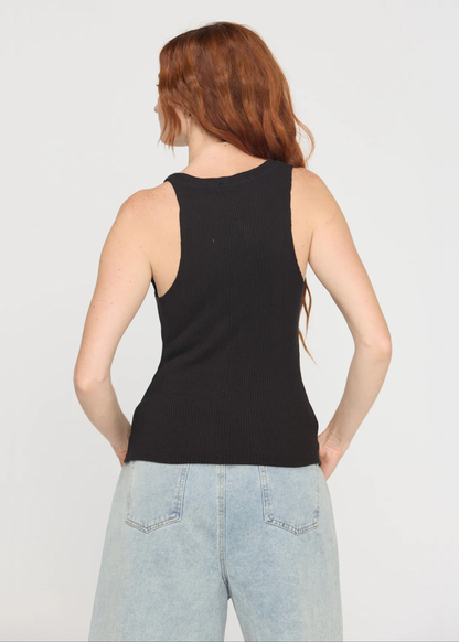 Woman turned around wearing a notch neck black tank top with denim shorts and a belt