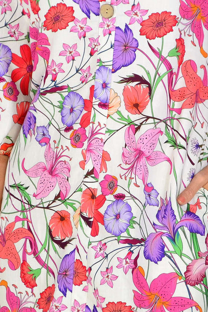 Purple pink floral linen blend tunic by La Mode displayed on a hanger, showcasing its light, airy fabric and vibrant floral pattern.