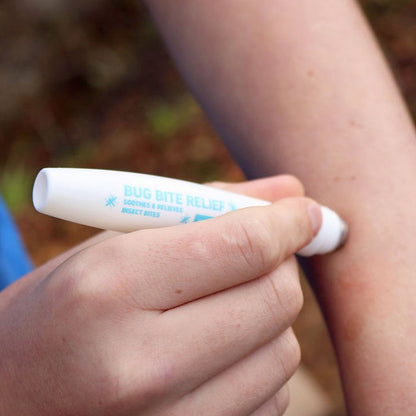 Person using a Pyramid bite and sting relief roll-on to treat a bite on their arm