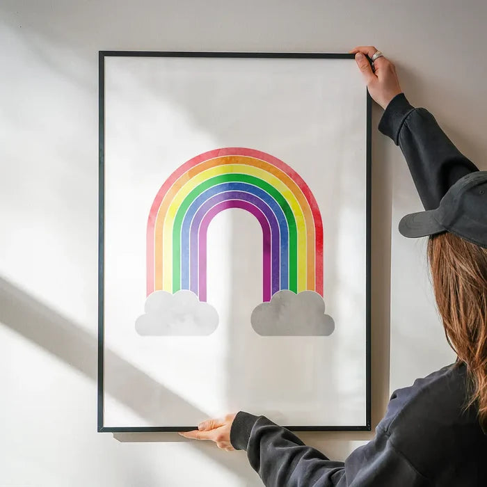 Rainbow Painting Print being hung on a wall in a black frame