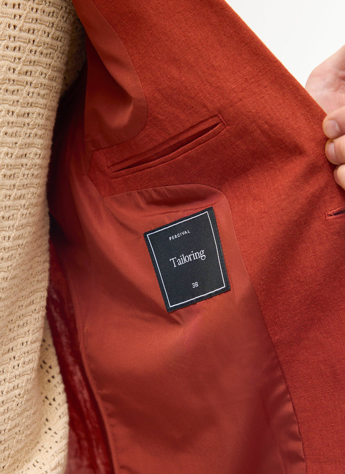 Close-up of the inside of the Percival rust linen blazer, showing the internal pocket and tailoring label.