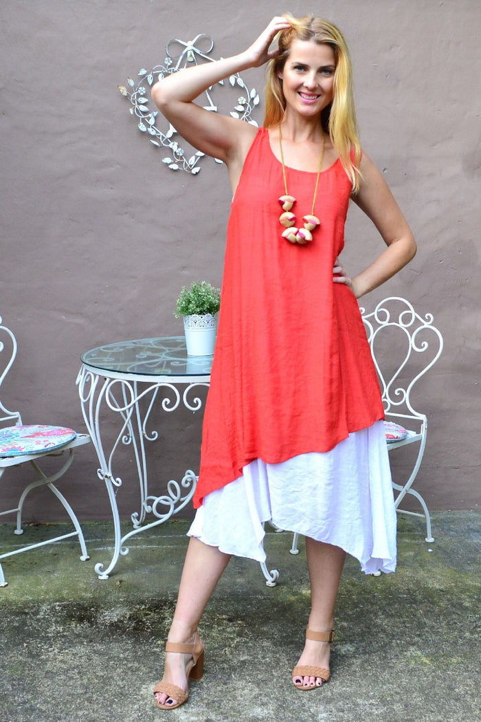 Rust asymmetrical hem tunic dress by Missy Q, featuring a loose fit and stylish design, displayed on a hanger.