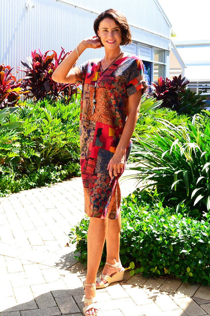 Rust orange Hourglass playful tunic dress with a relaxed fit, featuring a round neckline and short sleeves, displayed on a hanger.