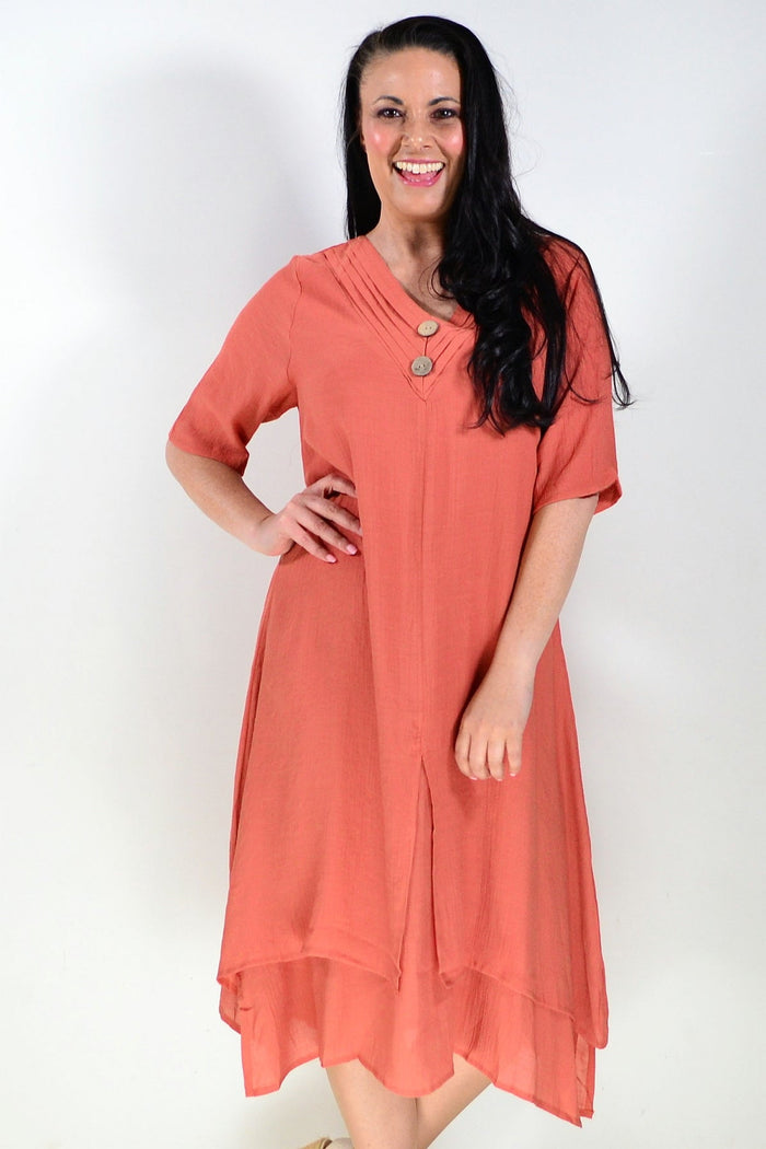 Rust-colored summer tunic dress by La Mode, lightweight fabric with a relaxed fit and short sleeves, displayed on a hanger.