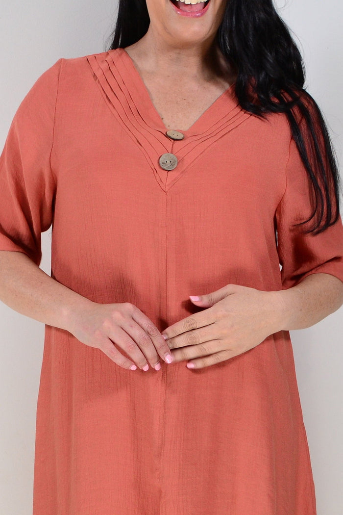 Rust-colored La Mode summer tunic dress with flowing fabric and sleeveless design, displayed on a hanger.