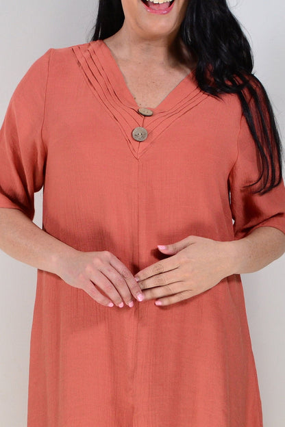 Rust-colored La Mode summer tunic dress with flowing fabric and sleeveless design, displayed on a hanger.