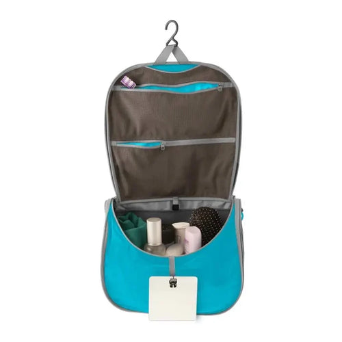 Sea To Summit Hanging Toiletry Bag Large in blue with the lid open to show the hanging  bar on a white background