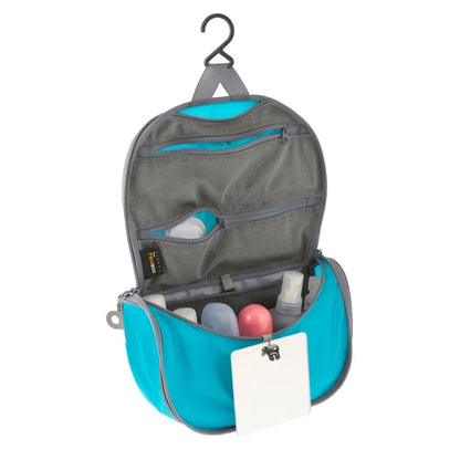 Sea To Summit small Hanging Toiletry Bag in blue with the hanging lid flap unzipped on a white background