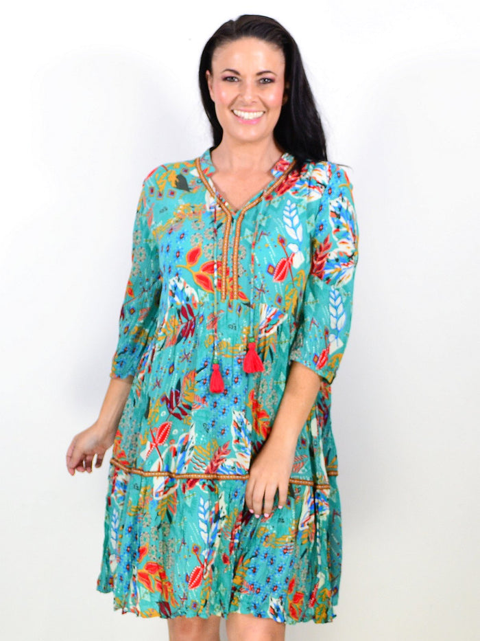 Orientique Serengetti V-neckline trim tunic dress displayed on a hanger, featuring a relaxed fit and stylish design.