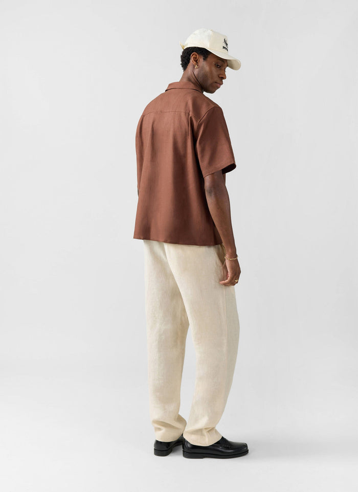 The Percival Short Sleeve Cuban Shirt in brown, a linen blend shirt, shown from behind on a model.