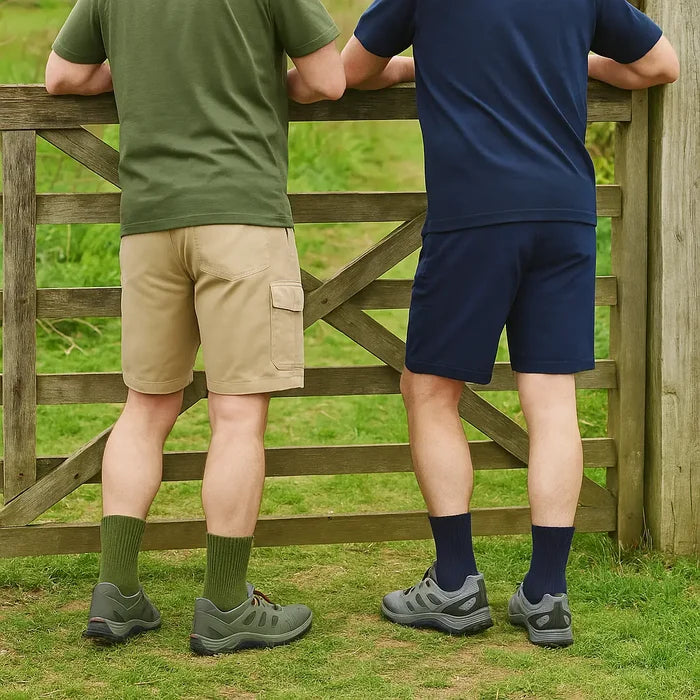 Two people leaning on a filed gate in shorts wearing Sub Zero short walking socks