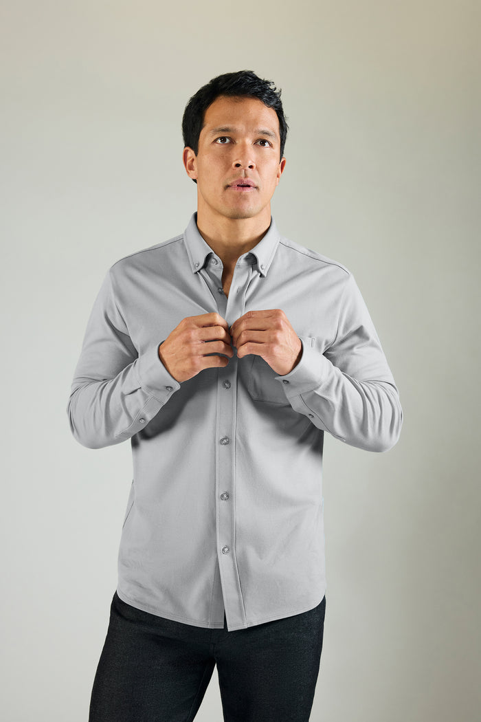 Image of a man wearing and buttoning Silver Pique Button Up in Monument