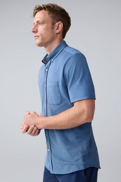 Side view of a man wearing SILVER Pique Short Sleeve Button Up in Total Eclipse Chambray Oxford