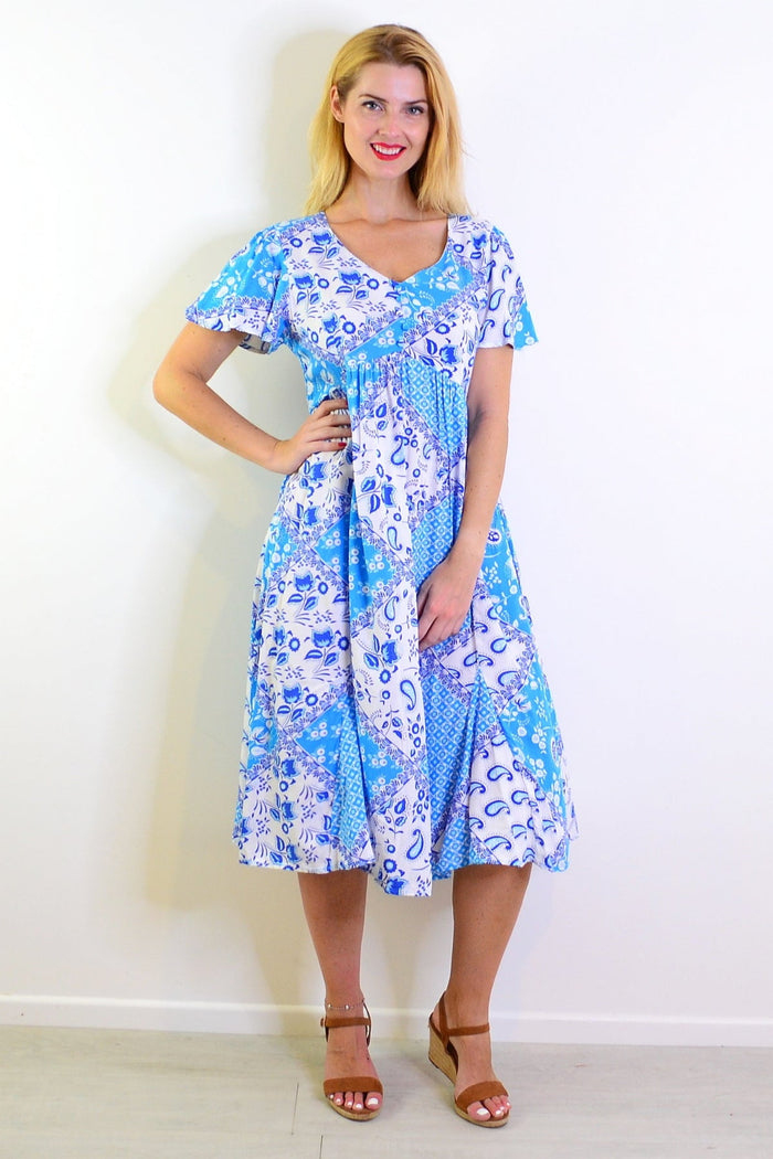 Soft blue floral paisley tunic dress by Hourglass, showing a flowy fabric and intricate floral pattern.