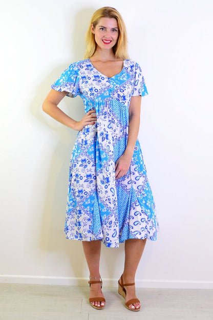 Soft blue floral paisley tunic dress by Hourglass, showing a flowy fabric and intricate floral pattern.