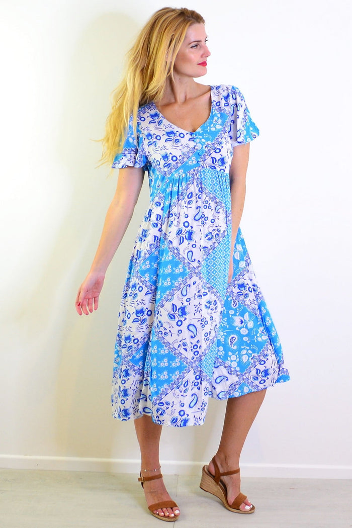 Soft blue floral paisley tunic dress by Hourglass, featuring a relaxed fit, long sleeves, and a vibrant, detailed floral pattern.