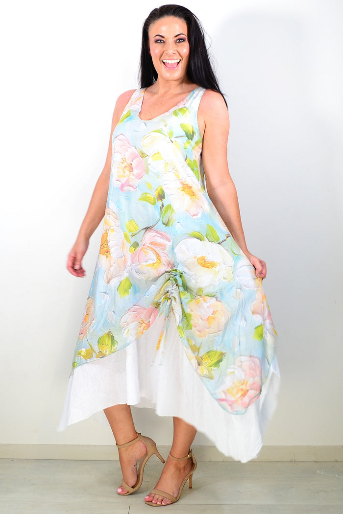 Soft blue and pink floral sleeveless tunic dress by Cali&Co displayed on a hanger with a flowing fabric design.