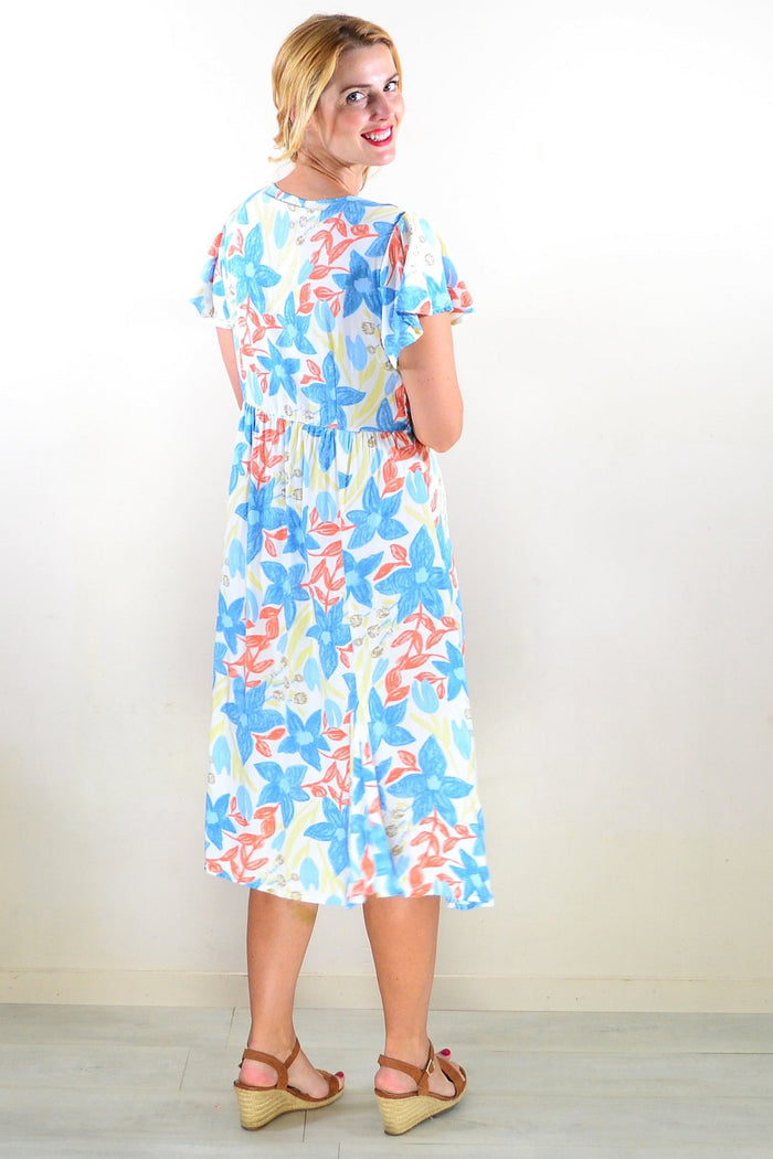 Soft garden floral tunic dress by Hourglass featuring a flowy silhouette and vibrant floral pattern.
