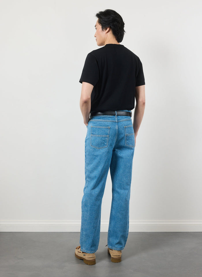 Back view of a model in the black Percival Spaceman t-shirt and blue jeans.