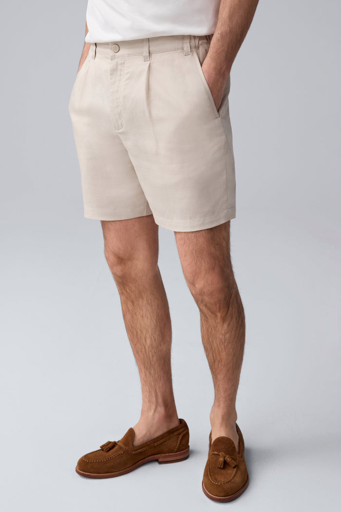 Side view of a man wearing Tech Linen  Pleated Short in Natural Linen