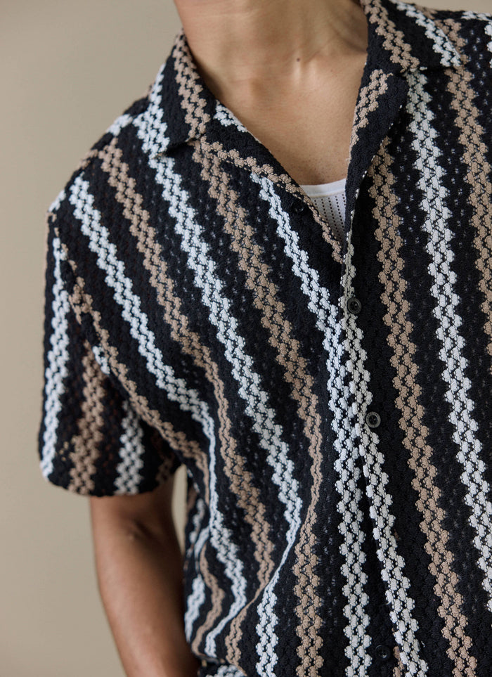 Close-up of the Percival Wade Crochet Boxy Shirt in black, showing the textured stripe pattern and revere collar.