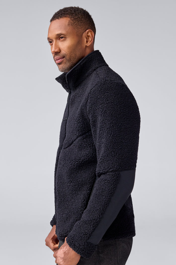 Side view of a man wearing WARMKNIT Sherpa Fleece in True Black