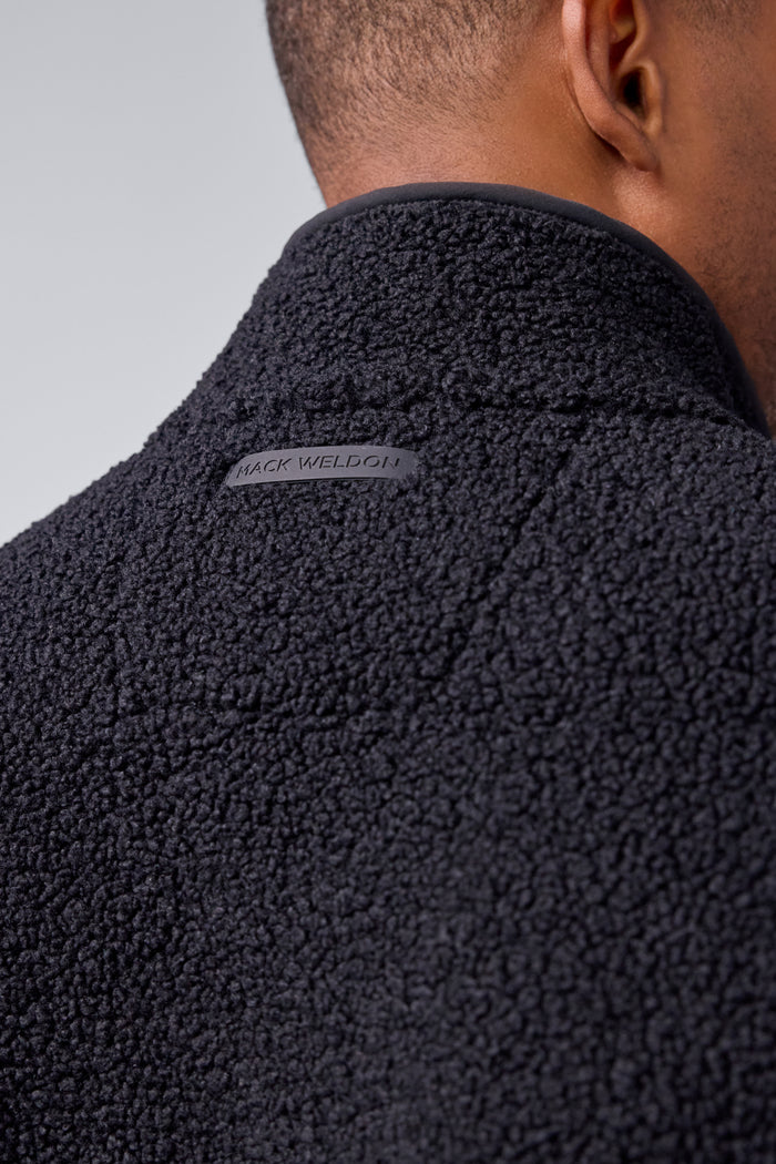 Detailed back view of a man wearing WARMKNIT Sherpa Fleece in True Black