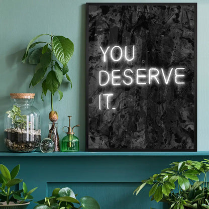 You Deserve It Neon Style Print, typography print black framed on a living room shelf